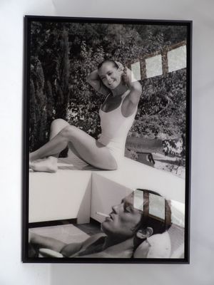 photographie en noir et blanc d'une femme en maillot de bain assise sur un rebord
