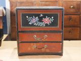 a small chest of drawers with flowers painted on it