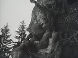 black and white photograph of a statue of a bear holding a baby bear