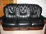 a black leather couch and two chairs in a living room