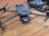 un petit drone noir posé sur une table en bois