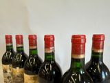 six bottles of wine are lined up in a row on a table