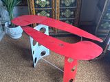 a red airplane sitting on top of a metal stand