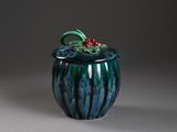 un vase bleu et vert orné d'une fleur rouge