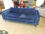 a blue couch that is sitting in the middle of a room