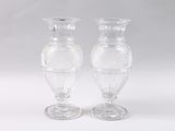 pair of clear glass vases sitting on top of a white table
