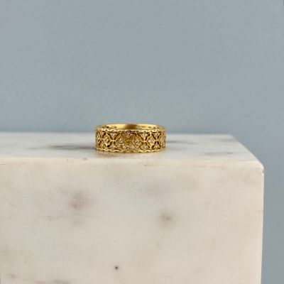 La bague en or repose sur un bloc de marbre blanc