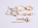 a lot of different rings and earrings on the table