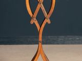 an old wooden table with two crossed legs on a wooden floor