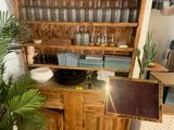 a wooden cabinet with a mirror on it and a potted plant in the corner of the room