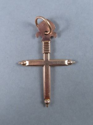 un gros plan d'une croix posée sur une table, avec une clé à l'intérieur