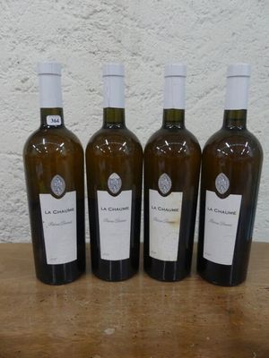 quatre bouteilles de vin sont alignées sur une table en bois