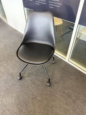 une chaise noire placée devant une fenêtre
