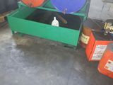 many barrels and drums in a room with cement flooring