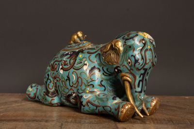 une statue d'éléphant posée sur une table, sur fond noir