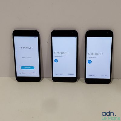 four cell phones are lined up on a table with a white background