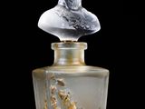 a bottle of perfume with a bust on top of it
