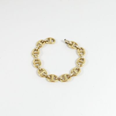 gros plan d'un bracelet en chaîne en or sur fond blanc