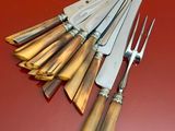 five knives and a fork on a red surface