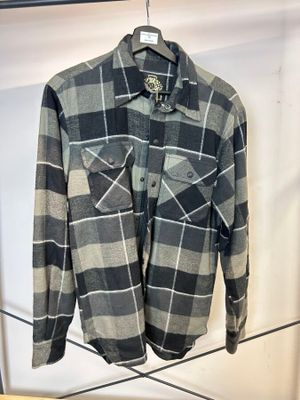 une chemise à carreaux gris et noirs suspendue à un portant