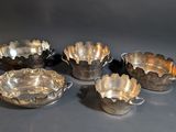 six silverplated bowls with handles and handles on a table