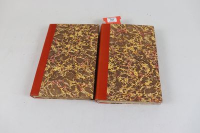 deux cahiers marron et rouges posés sur une table blanche