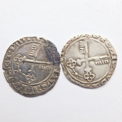 deux pièces d'argent posées l'une à côté de l'autre sur une surface blanche