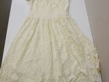 cream lace dress on display on a white table