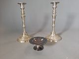 two silver candlesticks sitting next to each other on a table