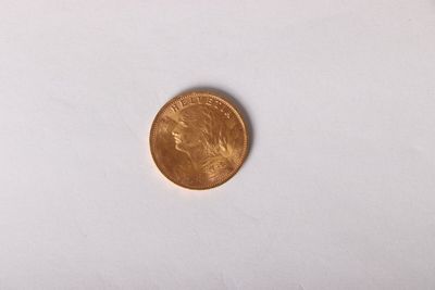 a gold coin on a white surface with a white background