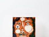 a picture of a painting of a face on a table