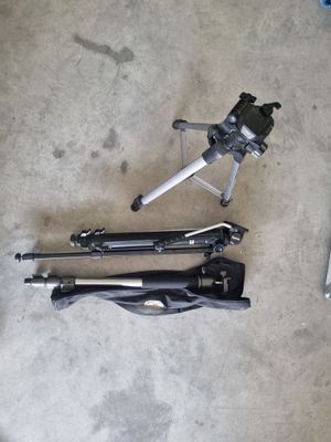 a tripod and a camera on the floor next to a laptop