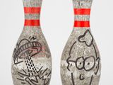 une paire de quilles de bowling en céramique ornées de graffitis sur un fond blanc