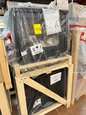 a pile of televisions sitting on top of pallets in a warehouse