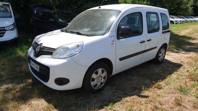 une petite camionnette blanche garée dans l'herbe