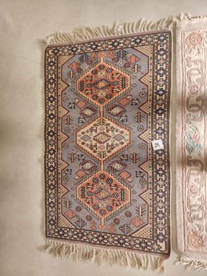 two rugs with fringes on them on a white surface