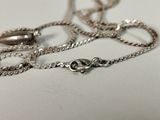 a close up of a silver chain with a ring on it