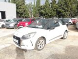a small white car that is parked in a parking lot