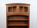 une photo d'une bibliothèque en bois surmontée d'une porte vitrée