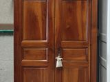 une armoire en bois posée à côté d'un réfrigérateur dans une pièce