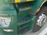 a green semi truck parked in a parking lot