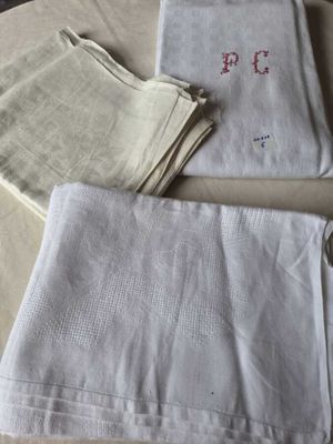 three white linen napkins on a table next to a pair of scissors