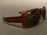 brown sunglasses with black lenses on a gray surface