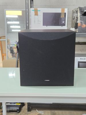 une enceinte noire posée sur une table blanche dans un magasin