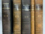cinq vieux livres sont alignés sur une surface blanche