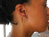 a woman that has a pair of earrings on her ear