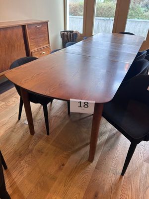 une table et des chaises dans une pièce avec une grande fenêtre