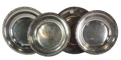 four silver plates are stacked on top of each other