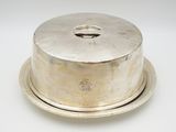 an antique silver plate with a domed lid on a white surface