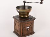 an old coffee grinder sitting on top of a wooden table